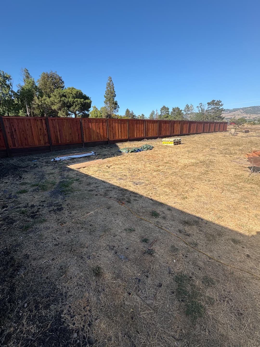Wide view of completed fence installation with clean, open yard space.
